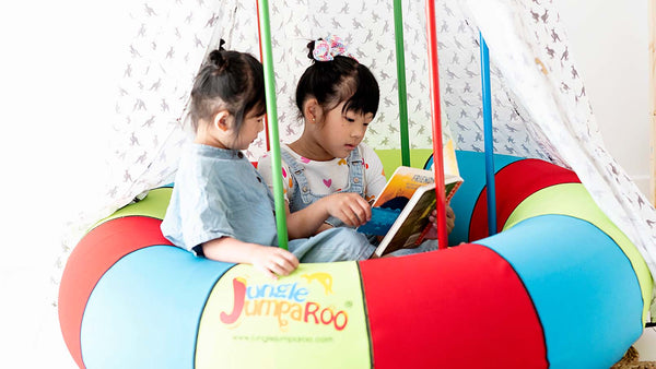 Two girls read a book on their Jungle Jumaroo.